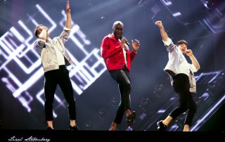 Boris René performing with two male dancers